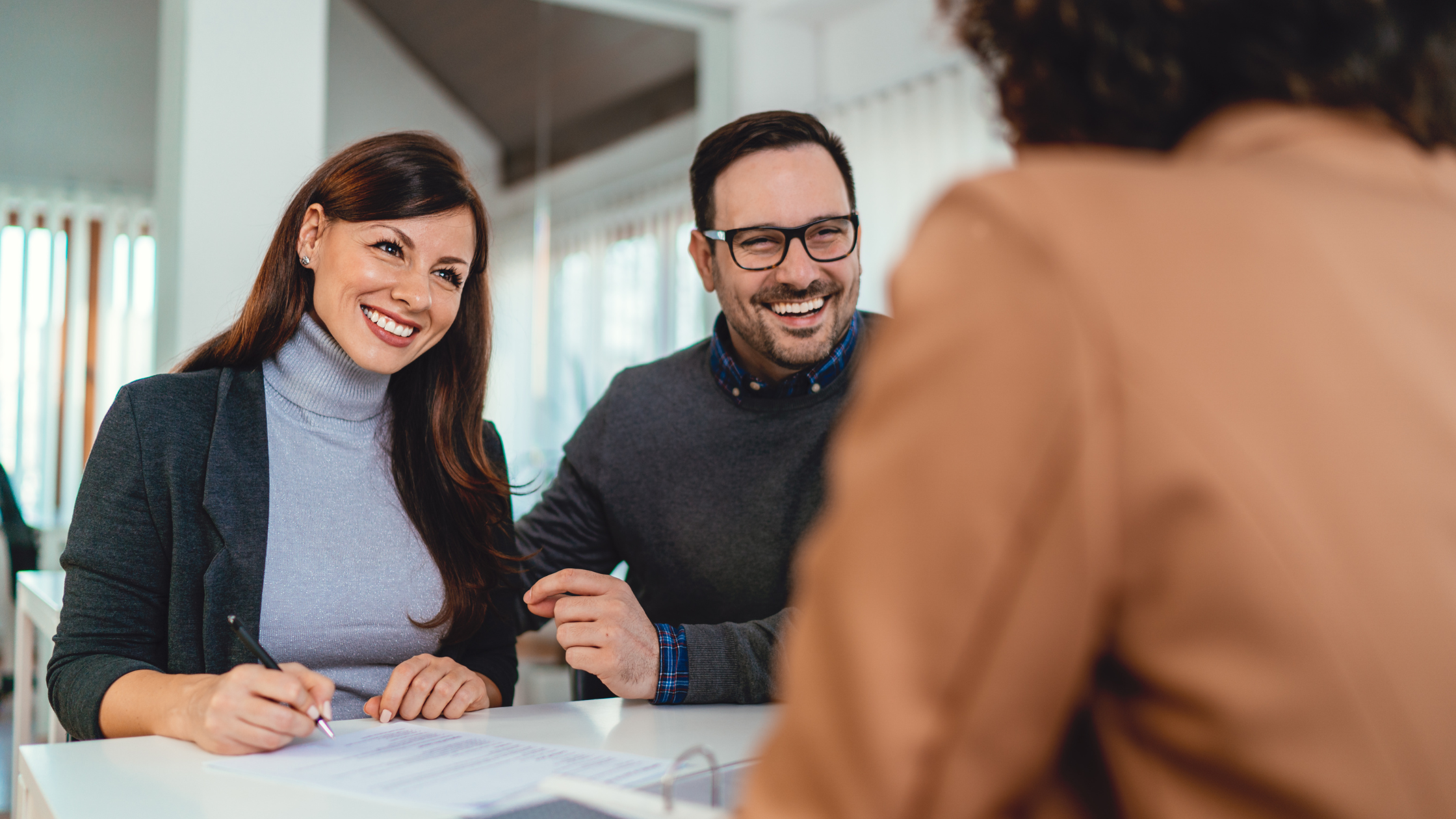 Couple smiling as they go through document collection process at a credit union