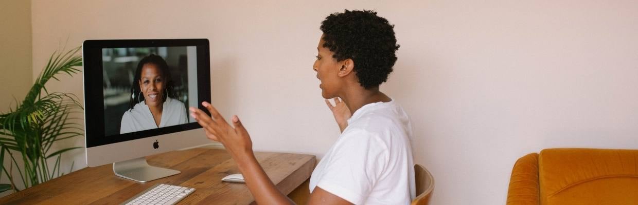 Blog image - 5 Ways to Improve Productivity in a Distributed Workforce - woman shown working remotely while on virtual meeting